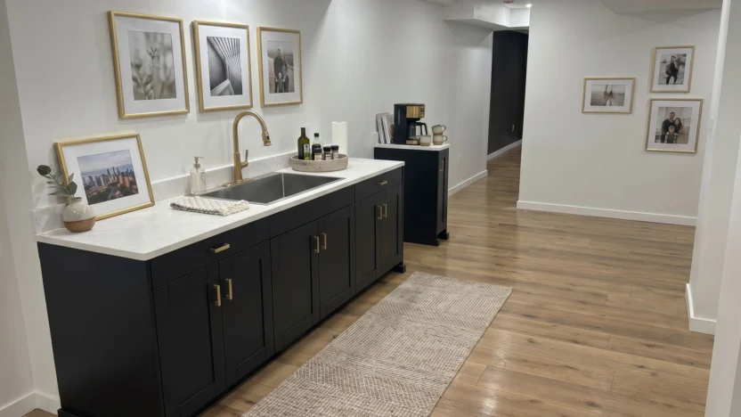Modern sink fixture with gold-framed photographs on the walls. A modern basement in the midwest.